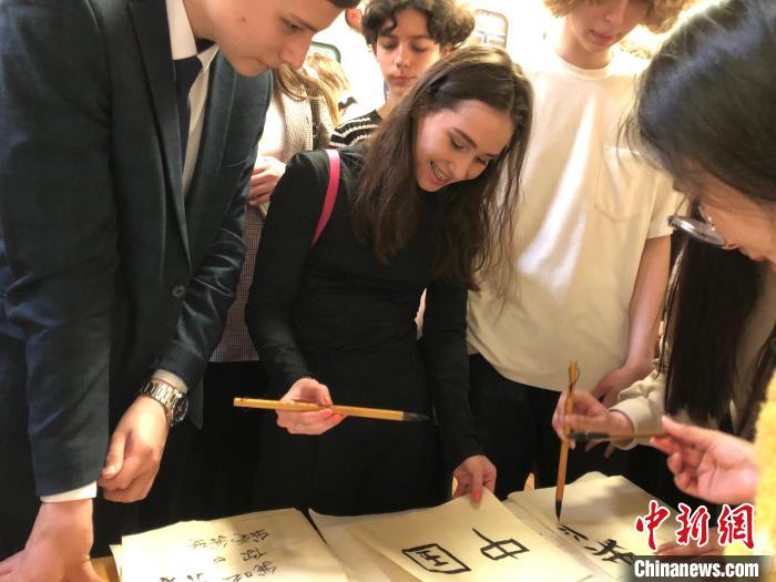 4月21日，莫斯科國立語言大學(xué)孔子學(xué)院附屬中學(xué)舉辦“國際中文日”活動，學(xué)生們學(xué)寫漢字?！∧箍茋⒄Z言大學(xué)孔子學(xué)院 供圖