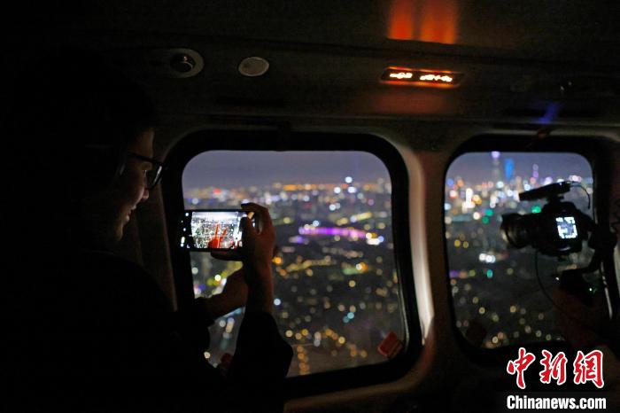 6月3日晚，游客乘坐上海新空直升機有限公司直升機開啟鳥瞰黃浦江空中圓夢之旅，并用手機拍攝城市夜景?！∫罅⑶?攝