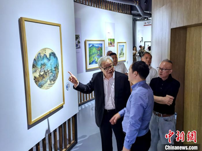 海峽兩岸藝術(shù)家畫展上，藝術(shù)家進(jìn)行藝術(shù)交流?！「毒窜?攝