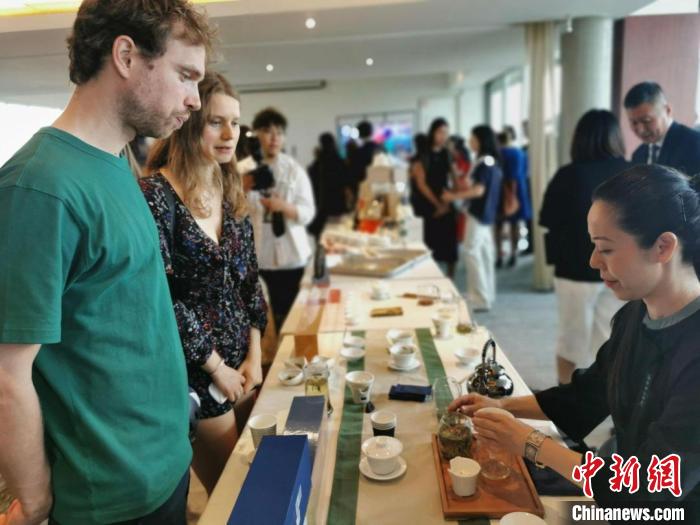 現(xiàn)場(chǎng)觀眾觀看中國展臺(tái)茶藝表演、了解茶文化?！【笜?攝