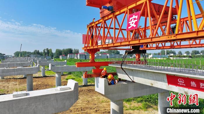 長25米重80噸的箱梁平穩(wěn)、精準地落在S314分離式立交橋25號和26號墩上?！⒂癫?攝