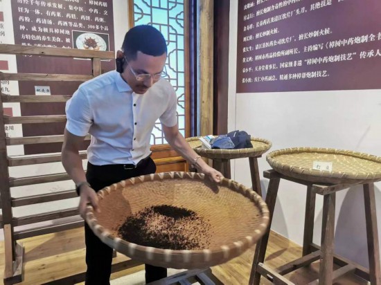 2023“一帶一路”媒體合作論壇聯(lián)合采訪團(tuán)團(tuán)員在非遺文化展示館體驗(yàn)中藥炮制技藝。（本報(bào)記者 黃超攝）