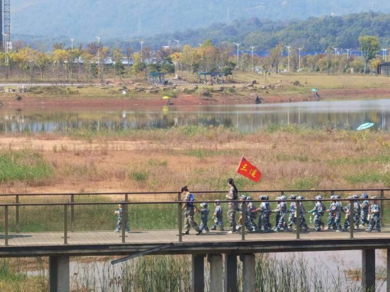 　　10月24日，秋游的幼兒園小朋友在老師帶領(lǐng)下走在清水塘公園里的木橋上。本報記者 常雯宜攝