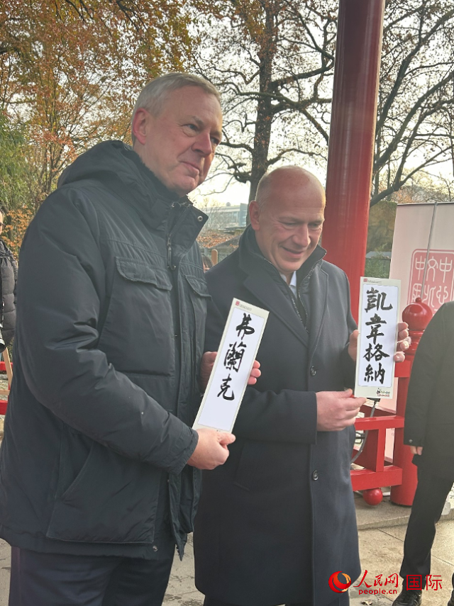 柏林市長韋格納（右）、動物園監(jiān)事會主席布魯克曼（左）手持中國文化中心工作人員現(xiàn)場手書的中文名字。人民網(wǎng)記者 徐馨攝