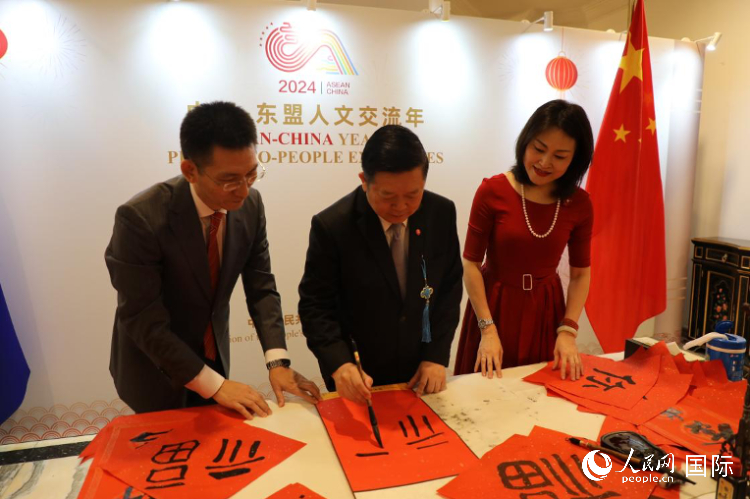 東盟秘書長高金洪（中）在活動現(xiàn)場寫福字。人民網(wǎng)記者曹師韻攝