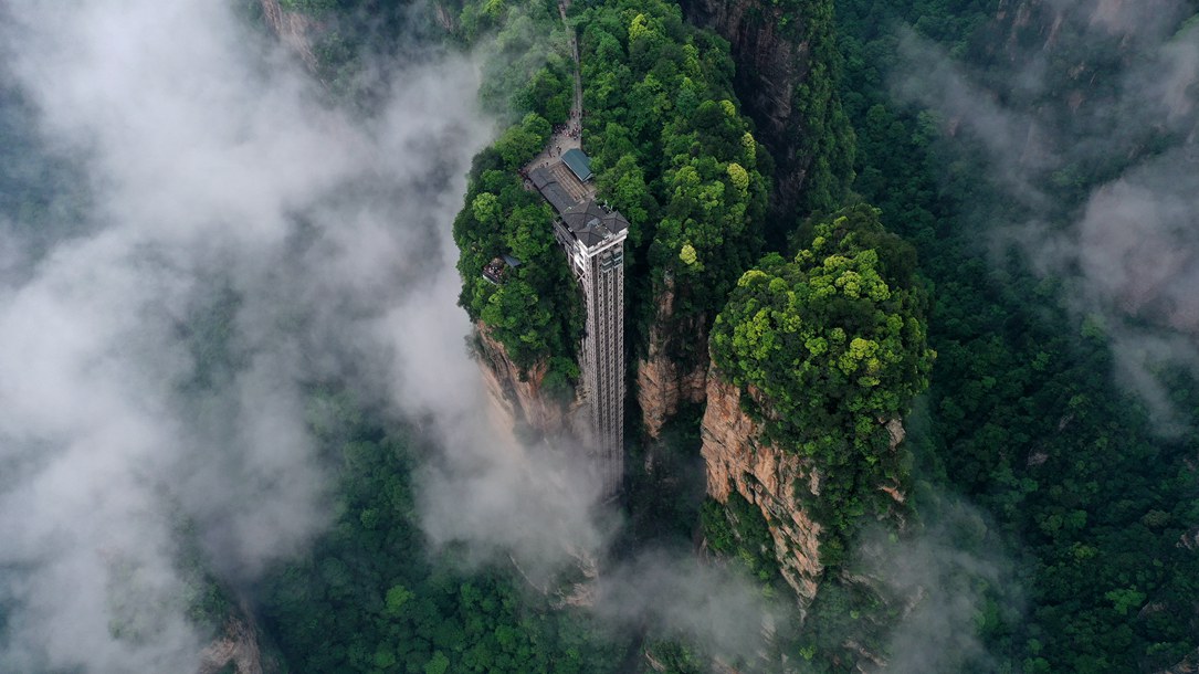 位于張家界武陵源景區(qū)的百龍?zhí)焯蓁偳对谠旗F繚繞的峰林間，雄偉壯觀。吳勇兵攝