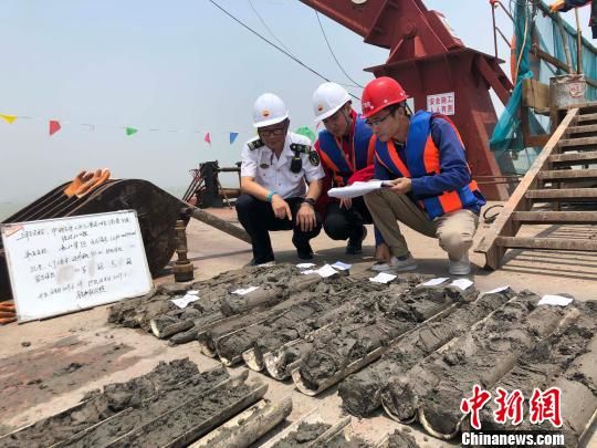 圖為勘察設(shè)計(jì)人員與海事局工作人員查看巖芯情況?！∥赫?攝