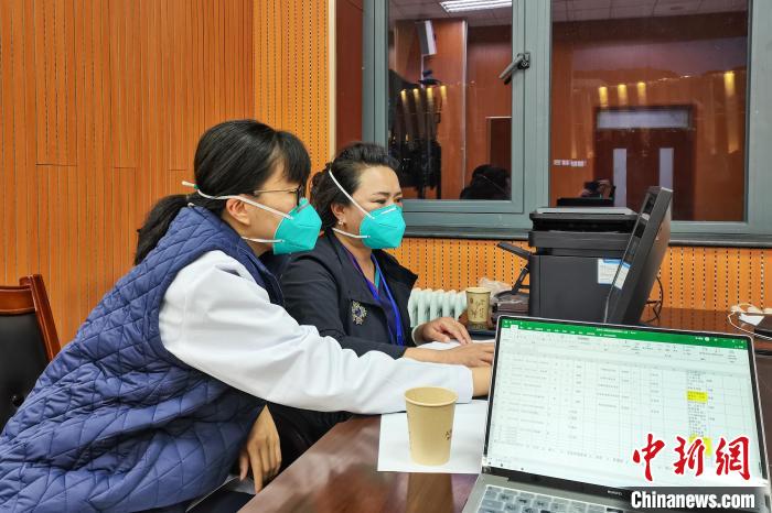 8月9日，楊蘇喬(左)在拉薩方艙醫(yī)院指揮部讀取艙內(nèi)患者胸部CT?！∈茉L者供圖