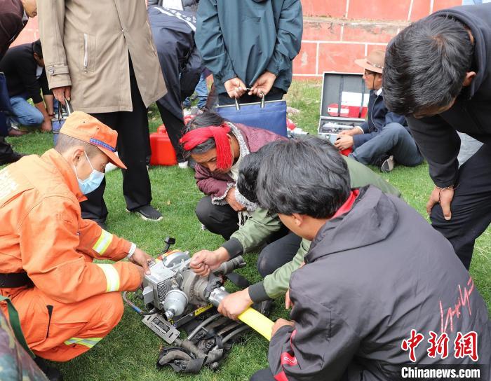 圖為森林消防員為護林員講解滅火裝備的使用方法?！〔际猩窒乐ш?供圖