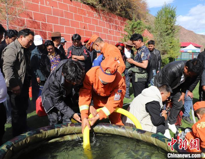 圖為森林消防員為護林員講解滅火裝備的使用方法。　昌都市森林消防支隊 供圖