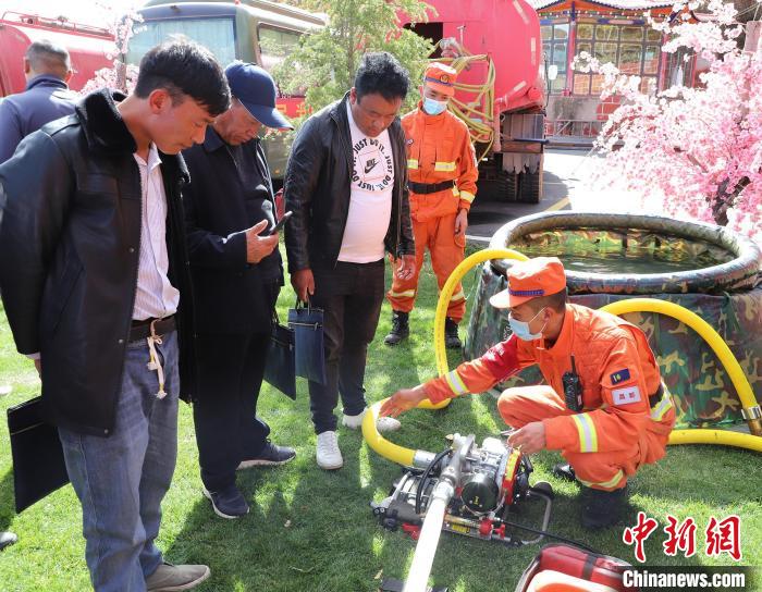 圖為森林消防員為護林員講解滅火裝備的使用方法。　昌都市森林消防支隊 供圖