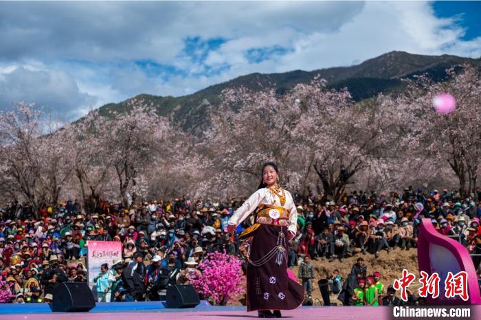 桃花林下精彩的“桃花仙子”選拔吸引村民或游客。　劉忠俊 攝