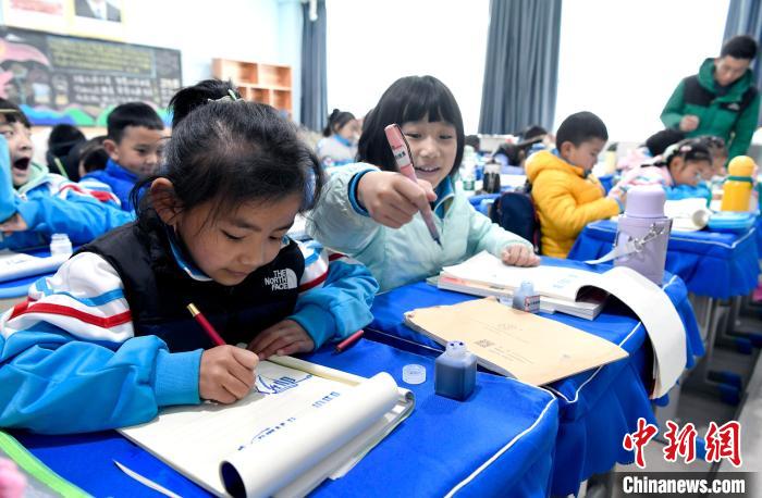 3月14日，西藏拉薩市第一小學(xué)一年級六班學(xué)生白瑪朗珍(圖左)在藏語文課上書寫藏文?！±盍?攝