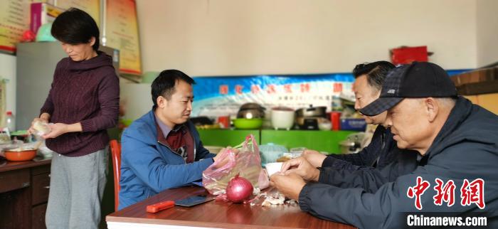 圖為扶貧路上“臨時(shí)一家人”準(zhǔn)備午餐?！∥航ㄜ?攝