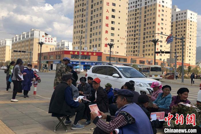 圖為會(huì)澤縣城易地扶貧搬遷安置點(diǎn)內(nèi)，老人們聚在廣場(chǎng)上聊天，身后是他們的新家?！】姵?攝