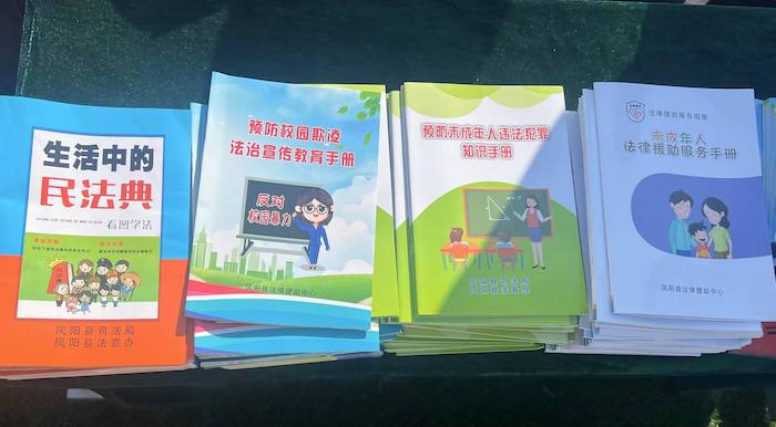 有關部門分發(fā)的普法宣傳冊。人民網 高清揚攝
