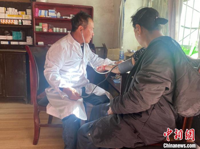 索木滾(左)為村民看病。　壤塘縣委宣傳部供圖