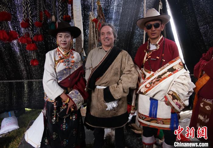 圖為一名外籍攝影師(中)身穿藏服和藏族民眾合影留念?！●R銘言 攝