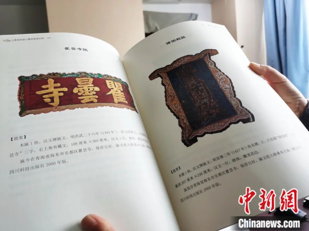古籍保護(hù)人員展示介紹明代朱元璋撰寫的青海瞿曇寺匾(左)的出版書籍。張?zhí)砀?攝