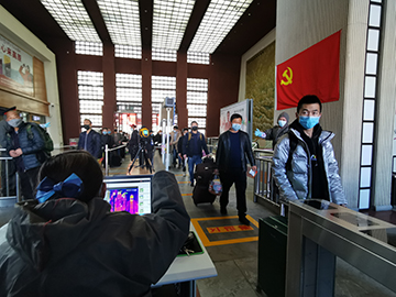 拉薩火車站工作人員對出站旅客進行紅外線測溫。趙越拍攝.jpg