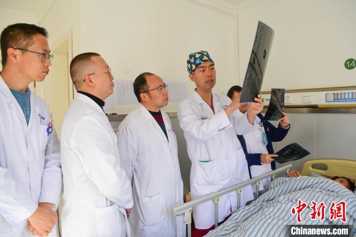 圖為何蔚副主任醫(yī)師(站右二)及團(tuán)隊討論患者病情?！∝暩聛硭?攝