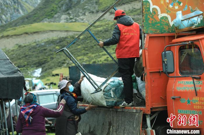 圖為工作人員幫助牧民們卸家具?！÷蹇?攝