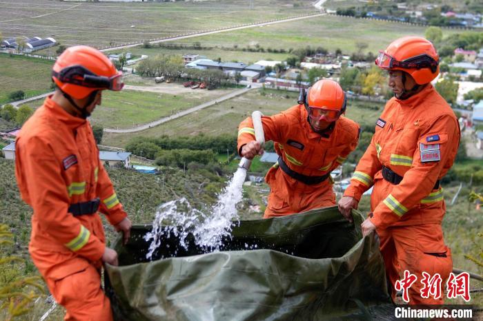 技能大練兵過(guò)程中，消防員在陡坡上向蓄水池注水?！±顕?guó)燾 攝