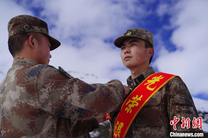 排長王朝偉(圖左)給退伍老兵佩戴大紅花。　西藏山南軍分區(qū)某團供圖