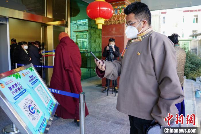 圖為政協(xié)委員掃場所碼進(jìn)入會場。　江飛波 攝