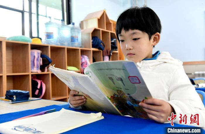 3月14日，西藏拉薩市第一小學(xué)一年級(jí)六班學(xué)生丁增樂(lè)吉在閱讀藏語(yǔ)課本?！±盍?攝