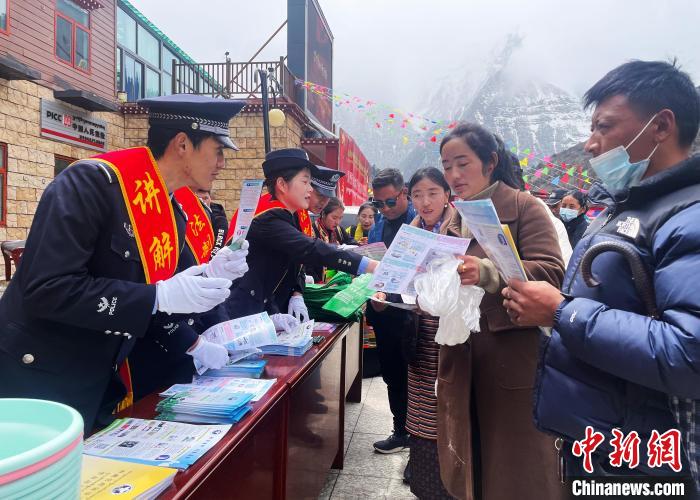 圖為山南玉麥邊境派出所民警為轄區(qū)群眾發(fā)放法律知識宣傳單?！＄婗?　攝