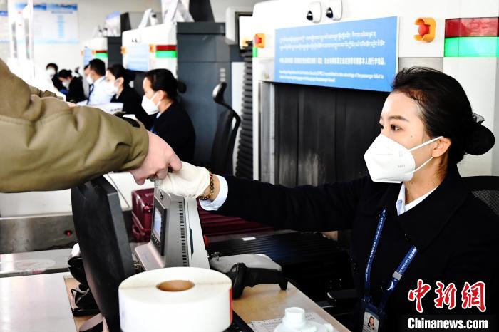 圖為機(jī)場工作人員為旅客辦理行李托運?！≈芎?攝