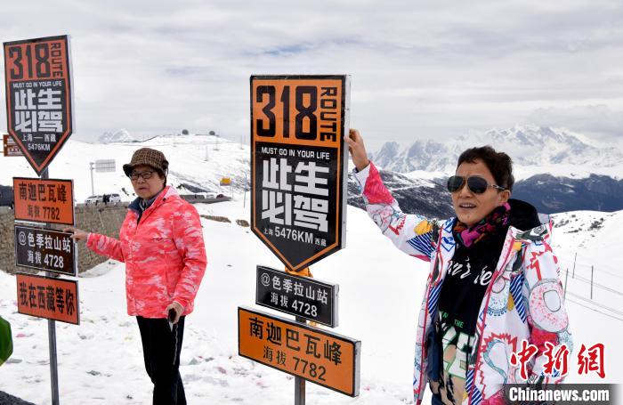 圖為5月14日，西藏林芝色季拉山觀景臺，游客與南迦巴瓦峰合影?！±盍?攝