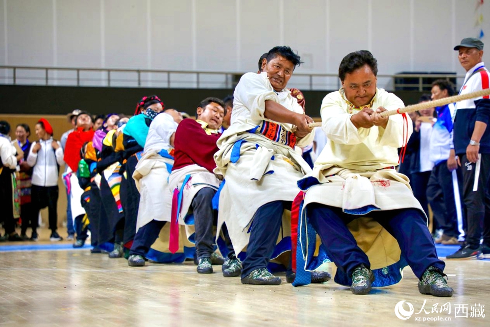 身著民族服裝的農(nóng)牧民選手在拔河比賽現(xiàn)場。